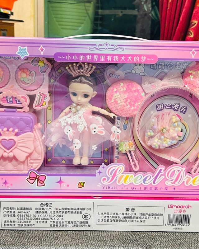 The wide Sweet Dream box on a grey floor: a doll in a crown stands at the centre, with a hand mirror, a bag and trays of hair clips laid out around her.