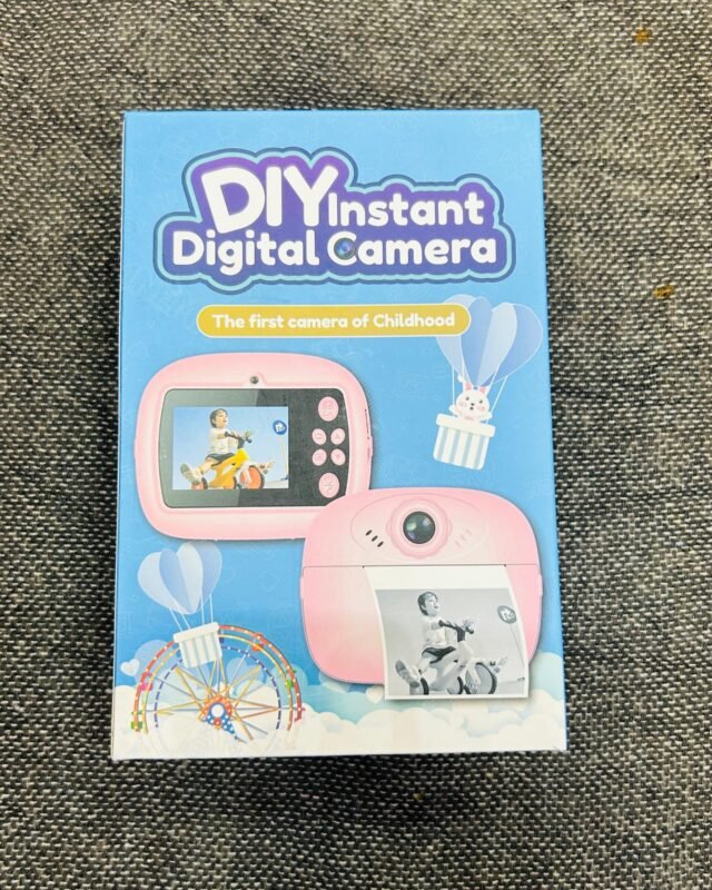 The same blue box seen straight on, its front filling the frame: the product name, a pink camera and a fairground wheel drawn under a hot-air balloon.